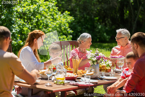 Image of happy family having dinner or summer garden party