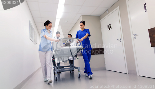 Image of medics with woman on hospital gurney at emergency