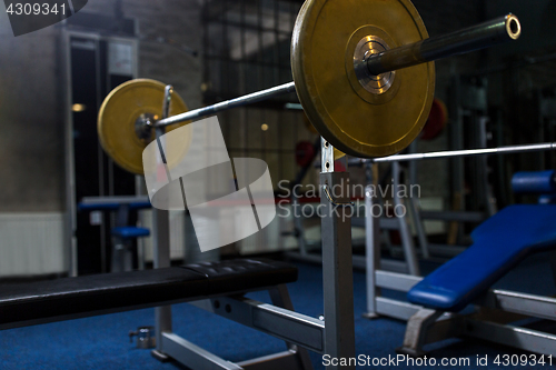 Image of weight bench with barbell in gym
