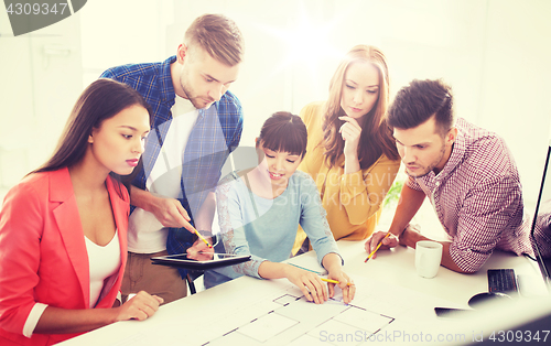 Image of creative team with blueprint working at office