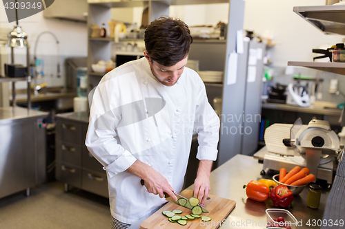 Image of happy male chef cooking food at restaurant kitchen