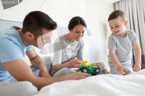 Image of happy family in bed at home or hotel room