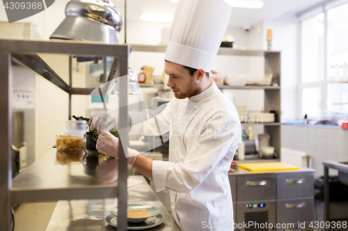 Image of male chef cooking at restaurant kitchen