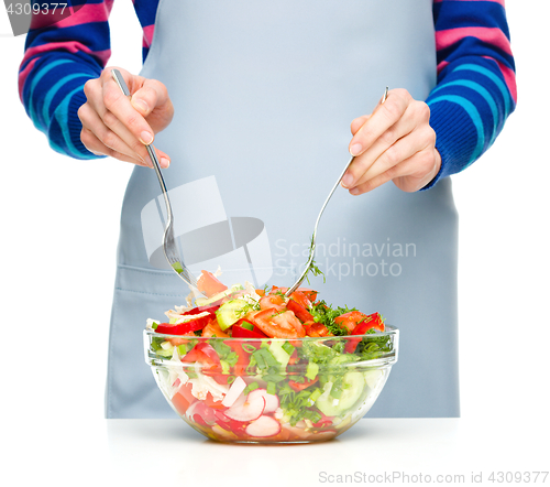 Image of Cook is mixing salad