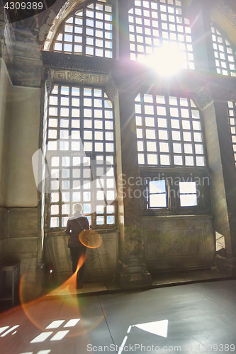 Image of Silhouette of a woman on the window. Haze and sunlight beam