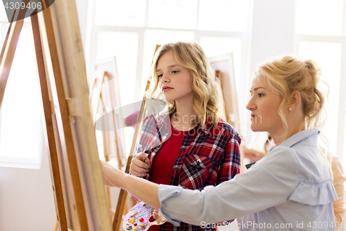 Image of student and teacher with easel at art school