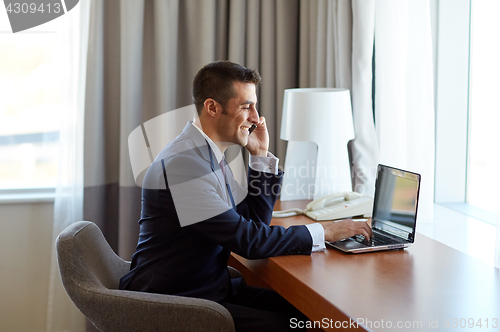 Image of businessman with laptop and smartphone at hotel