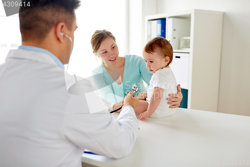 Image of doctor with stethoscope listening baby at clinic