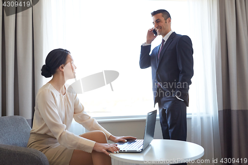 Image of business team with laptop working at hotel room