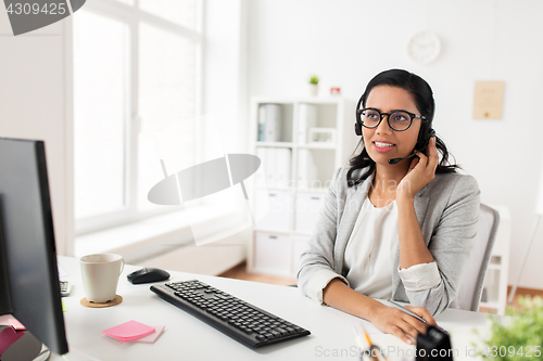 Image of businesswoman with headset and computer at office
