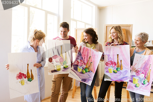 Image of group of artists with pictures at art school