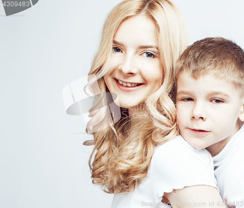 Image of young modern blond curly mother with cute son together happy smiling family posing cheerful on white background, lifestyle people concept, sister and brother friends 