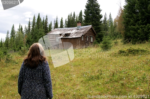 Image of Woman looking at old cottage