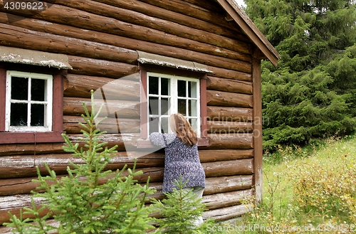 Image of Woman looking at old cottage