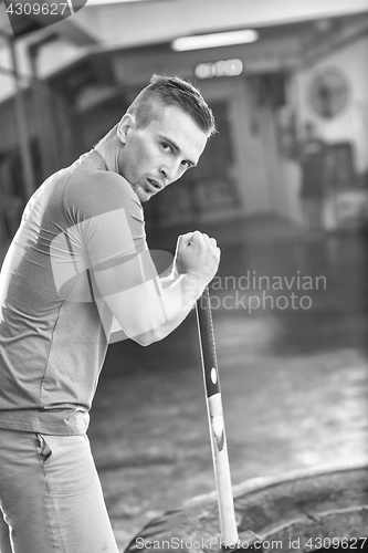 Image of man workout with hammer and tractor tire