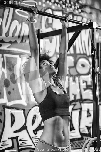 Image of black woman doing pull ups