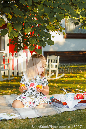 Image of The little girl sitting on green grass