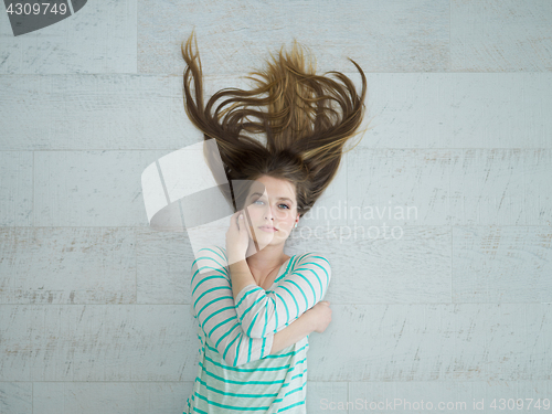 Image of beautiful girl lying on floor