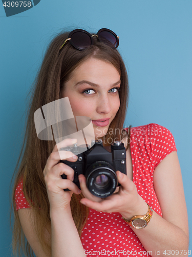 Image of beautiful girl taking photo on a retro camera