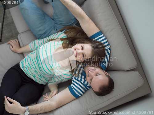 Image of young handsome couple hugging on the sofa