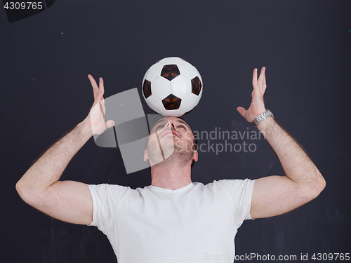 Image of man playing with soccer ball isolated over grey