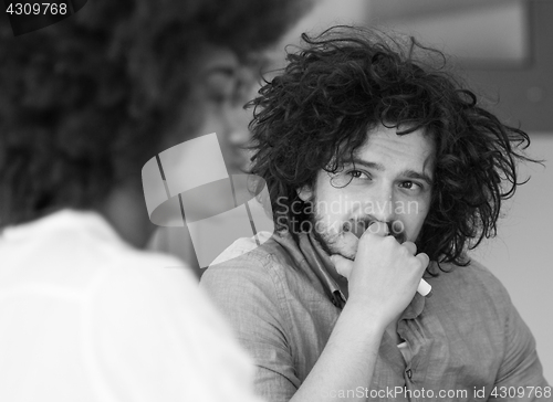 Image of Businessman looking at his colleague at work