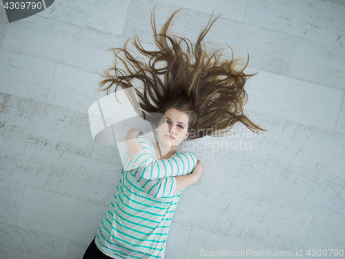 Image of beautiful girl lying on floor