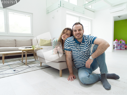 Image of young handsome couple hugging on the sofa