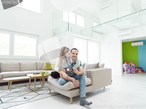 Image of young handsome couple hugging on the sofa