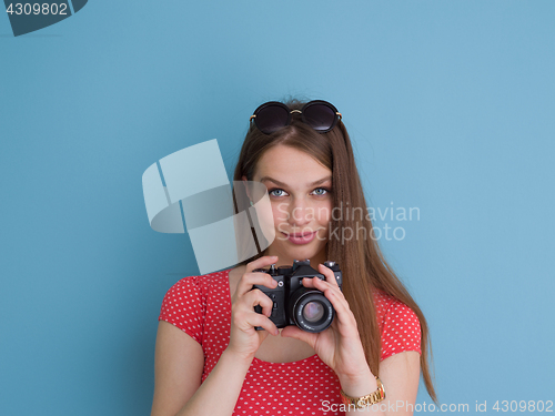 Image of beautiful girl taking photo on a retro camera