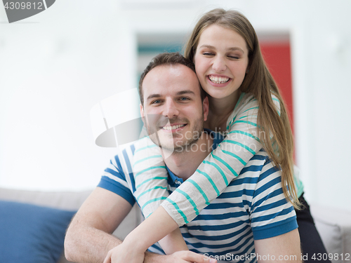 Image of young handsome couple hugging on the sofa