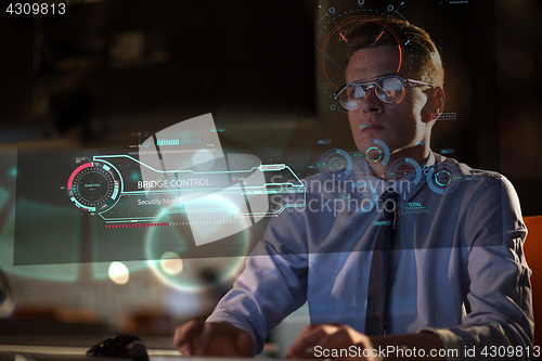 Image of man working on computer in dark office