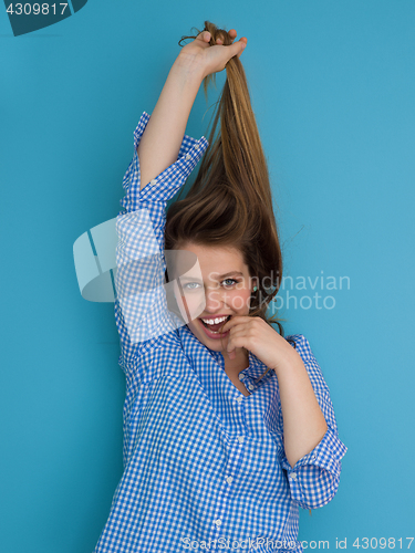 Image of young woman playing with her long silky hair