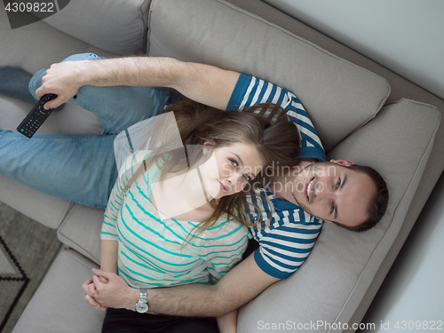 Image of young handsome couple hugging on the sofa