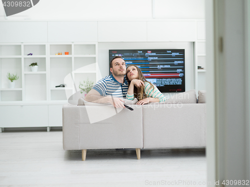 Image of Young couple on the sofa watching television