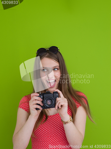 Image of smilling girl taking photo on a retro camera