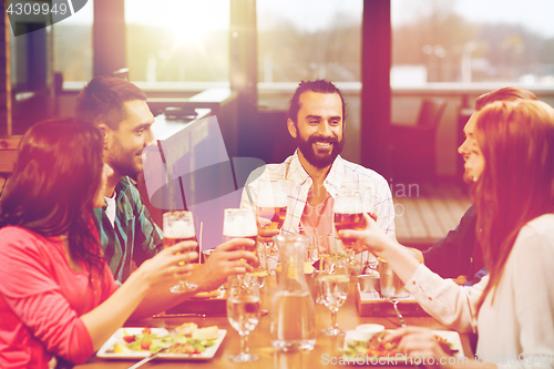 Image of friends dining and drinking beer at restaurant