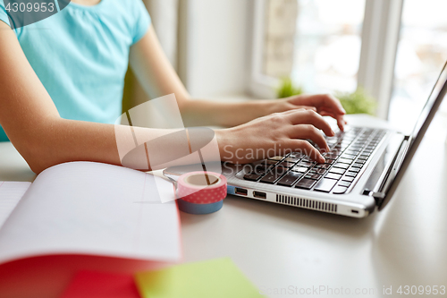 Image of girl typing on laptop at home