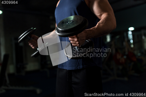 Image of close up of man with dumbbells exercising in gym