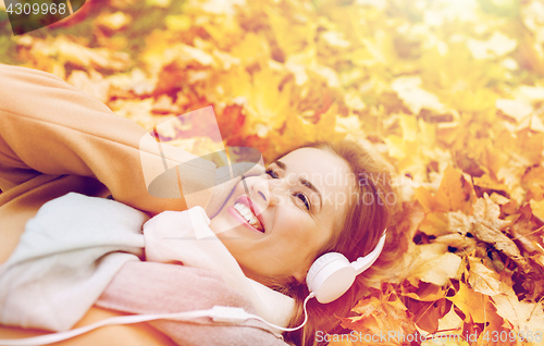 Image of woman with headphones listening to music in autumn