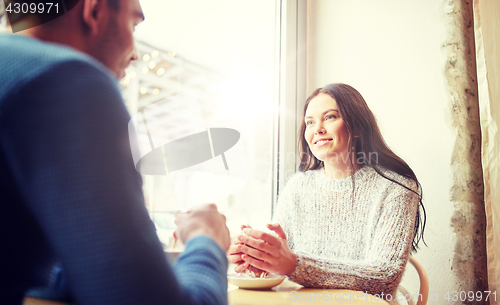 Image of happy couple drinking tea and coffee at cafe