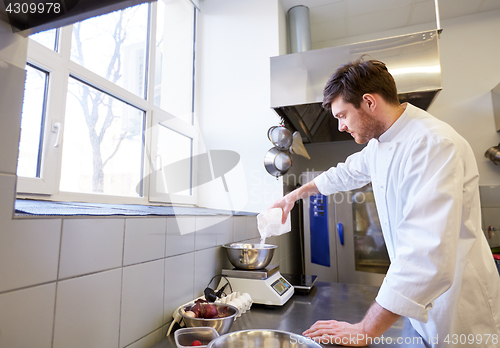 Image of happy male chef cooking food at restaurant kitchen