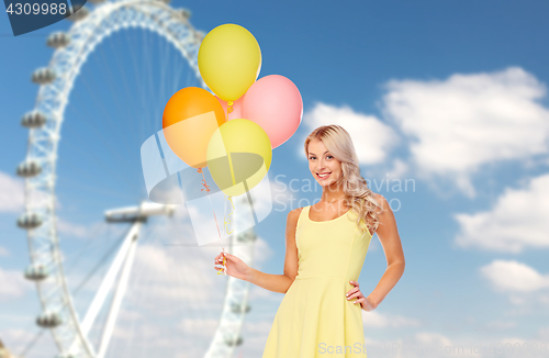 Image of happy woman with air balloons over ferris wheel