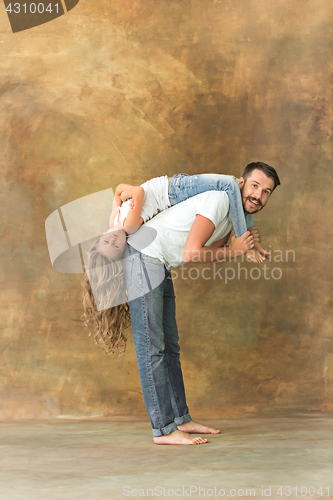 Image of Man hugging her teenage daughter at brown