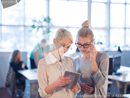 Image of Pretty Businesswomen Using Tablet In Office Building during conf