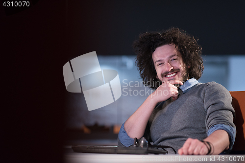 Image of man working on computer in dark startup office