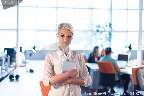 Image of woman working on digital tablet in night office