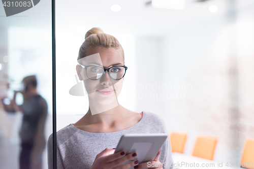 Image of woman working on digital tablet in night office