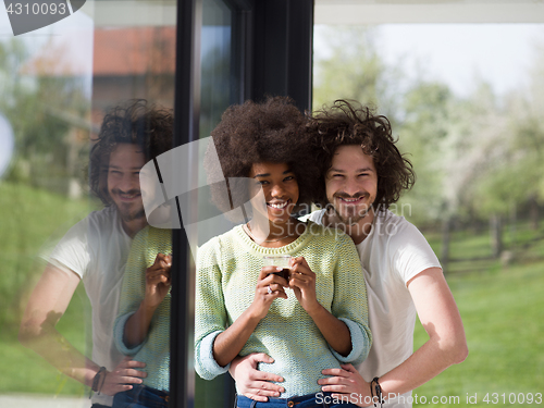 Image of happy multiethnic couple relaxing at modern home indoors