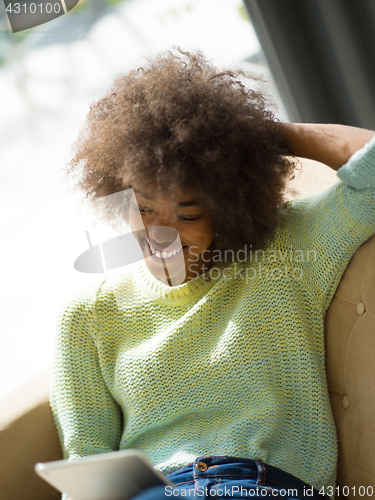 Image of young african american woman at home using digital tablet